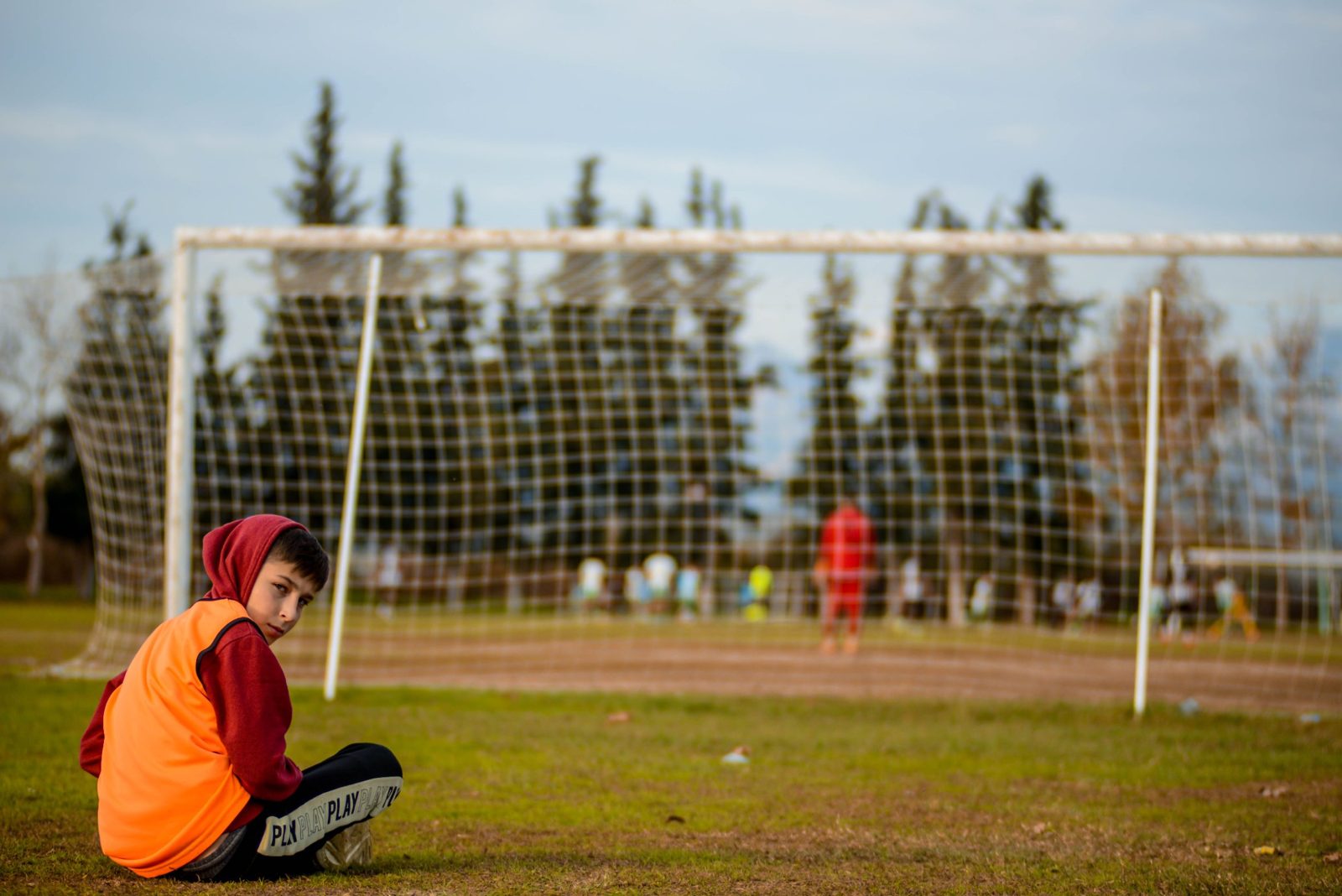 Jonge speler zit langs het veld tijdens de training, voeding voor een voetballend kind van 10 jaar